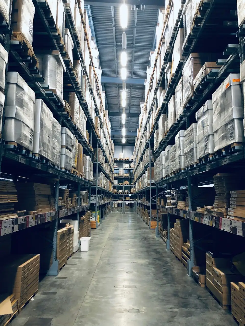A long warehouse aisle stacked with palletised goods