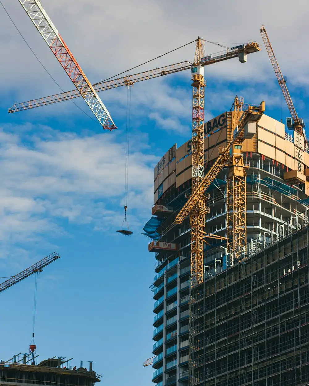A residential building under construction beside a tower crane