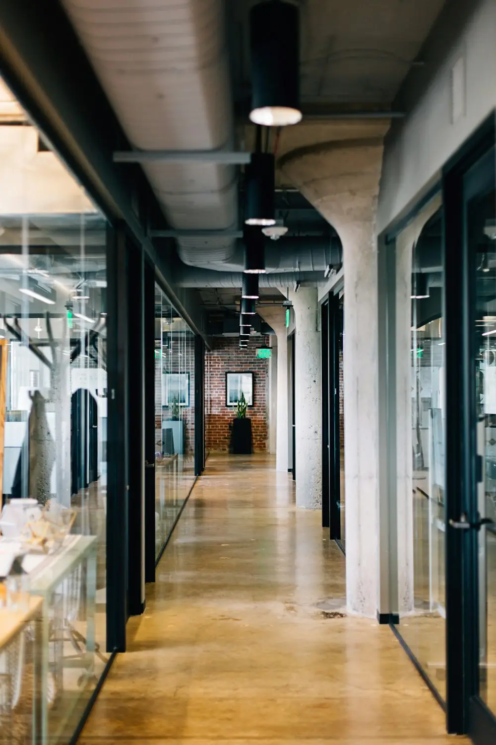 A corridor of glass-walled meeting rooms