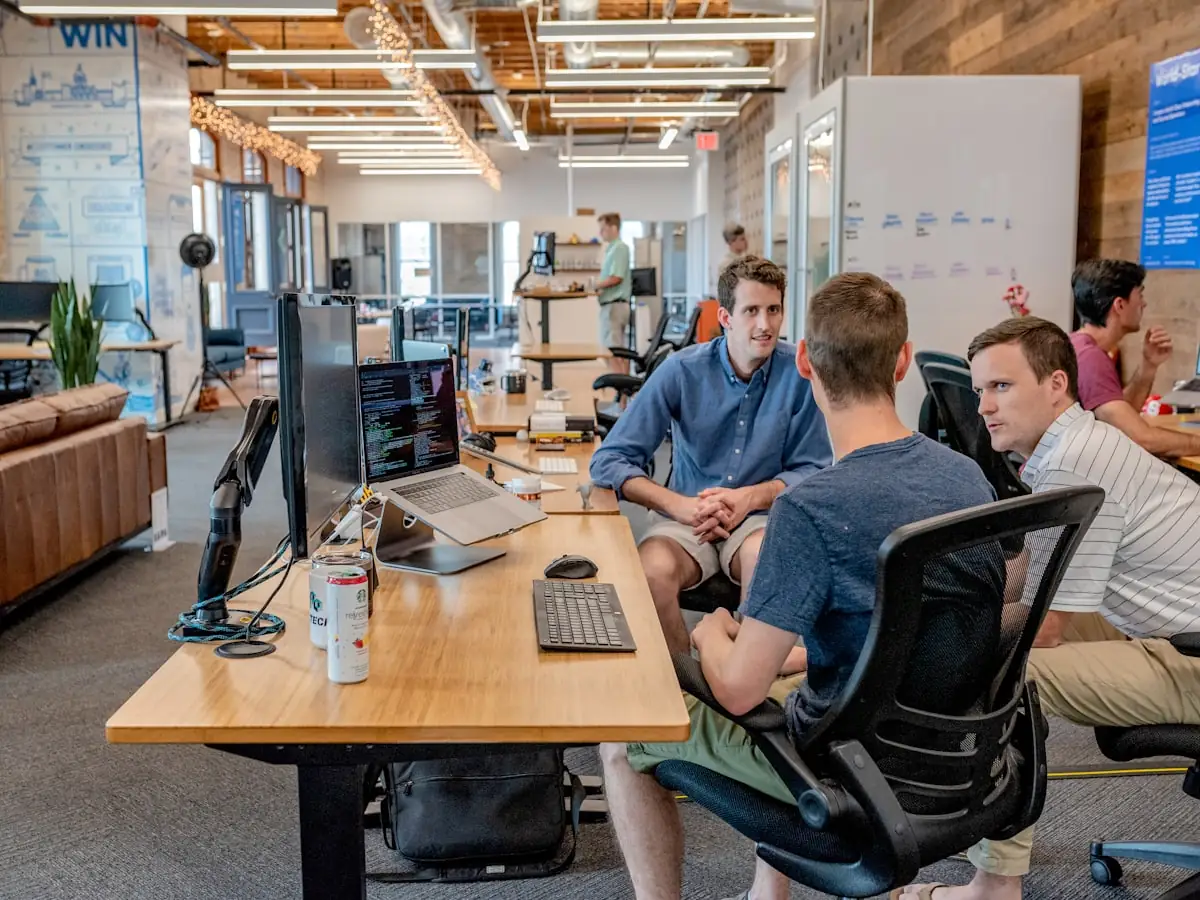 Three colleagues in discussion at a desk