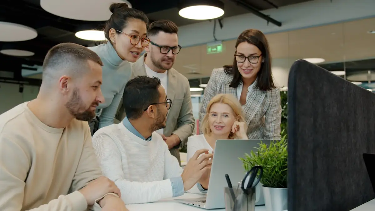 A team collaborating around a laptop