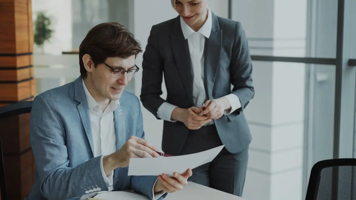 Two colleagues examining a document together at a desk