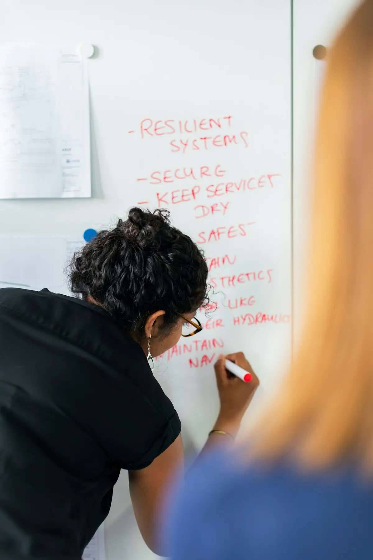 A consultant working through a process map on a whiteboard